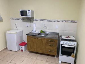 Elle comprend une petite cuisine équipée d'un évier et d'un réfrigérateur. dans l'établissement RCM Vilas - STUDIO n 03, à Joinville