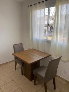 a dining room table with two chairs and a window at RCM Vilas - STUDIO n 05 in Joinville