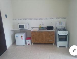 a small kitchen with a stove and a microwave at RCM Vilas - Studio n 06 in Joinville