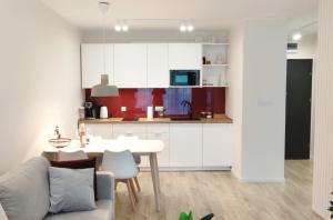 a kitchen and living room with a table and a couch at Apartament Marina Bay & SPA in Dziwnów