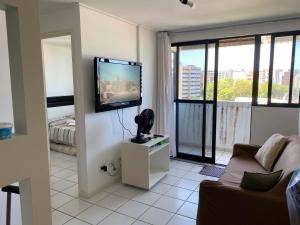 a living room with a couch and a flat screen tv at NEO I - Ap. 627 in Maceió
