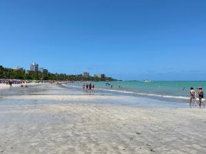 a group of people walking on a beach at NEO I - Ap. 627 in Maceió