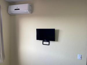 uma televisão de ecrã plano na parede de um quarto em RCM Vilas - STUDIO n 14 em Joinville