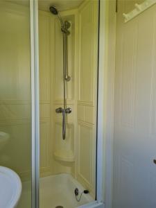 a bathroom with a shower and a sink at Warden spring in Leysdown-on-Sea