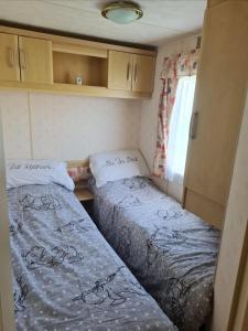 2 camas en una habitación pequeña en una caravana en Warden spring en Leysdown-on-Sea