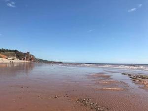 a beach with the ocean and the shoreline at The Old Scout Hut, Sidmouth in Sidmouth