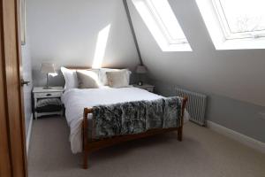 um quarto com uma cama grande e uma clarabóia em The Old Scout Hut, Sidmouth em Sidmouth