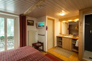 a bedroom with a bed and a sink and a mirror at Historic Hotel du Pillon in Les Diablerets