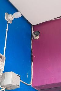 a wall with two lights on top of a purple wall at OYO 93101 Al-ainah Family Homestay in Medan