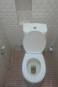 a bathroom with a white toilet in a stall at OYO 93101 Al-ainah Family Homestay in Medan