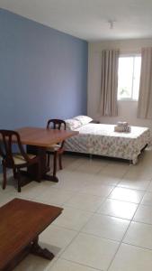 a bedroom with a bed and a table and a table and chairs at RCM Vilas - STUDIO n18 in Joinville