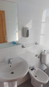 Baño blanco con lavabo y aseo en Hotel Rural-Restaurante Los Olivos, en Almería