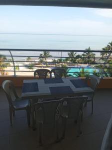 d'une table et de chaises sur un balcon avec vue sur la plage. dans l'établissement Hermoso departamento frente al mar, à Tonsupa