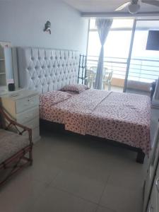 - une chambre avec un lit, une chaise et une fenêtre dans l'établissement Hermoso departamento frente al mar, à Tonsupa