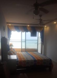 - une chambre avec un lit en face d'une fenêtre dans l'établissement Hermoso departamento frente al mar, à Tonsupa