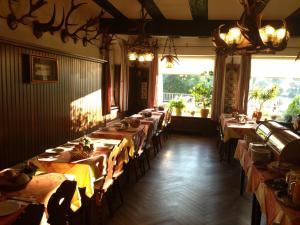 ein Esszimmer mit Tischen und Stühlen und einem großen Fenster in der Unterkunft Hotel Cafe Lieb in Bamberg