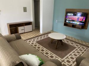 uma sala de estar com um sofá e uma mesa em RCM Vilas - YELLOW HOUSE em Joinville