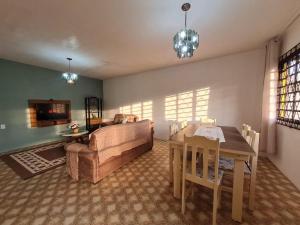 uma sala de estar com um sofá e uma mesa de jantar em RCM Vilas - YELLOW HOUSE em Joinville