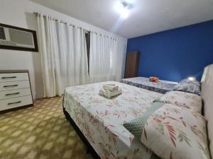 a bedroom with two beds and a dresser at RCM Vilas - YELLOW HOUSE in Joinville