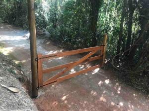 une porte en bois sur un chemin dans les bois dans l'établissement Reserva Atibaia / Casa de Montanha, à Atibaia
