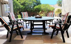 einen Tisch und Stühle auf einer Terrasse in der Unterkunft Cape Halal Haven in Kapstadt