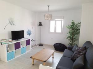 - un salon avec un canapé et une télévision dans l'établissement Casa mirador Perea, à Malaga