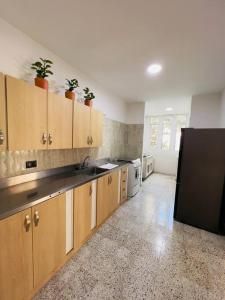 een keuken met houten kasten en een zwarte koelkast bij Apartamento en el poblado in Medellín