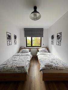 2 camas en una habitación con ventana en Miejska Stodoła, en Biała Podlaska