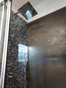 a bathroom with a shower with a glass tile wall at Studio em Machico in Machico