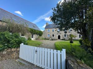 a white fence in front of a house at LE DOMAINE DE COAT ROGAN La chambre romantique in Pommerit-Jaudy