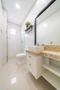 a bathroom with a sink and a toilet at Edifício Costa Brava em Canto Grande Bombinhas in Bombinhas