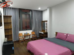 a bedroom with a bed and a table and chairs at Bơ House hotel in Da Lat