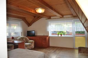 a living room with a couch and a tv and windows at Central Łeba Suites in Łeba +35 photos