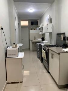 a kitchen with white cabinets and a stove top oven at Apartamento Miraflores in Lima