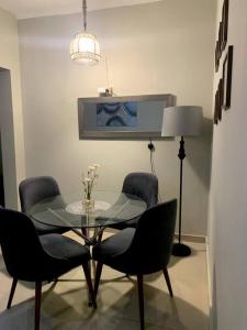 a dining room with a glass table and chairs at Apartamento Miraflores in Lima