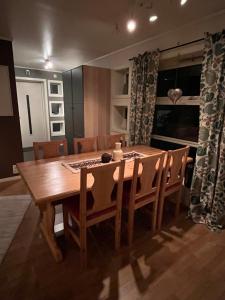 uma sala de jantar com uma mesa de madeira e cadeiras em Lykkebo em Tromsø