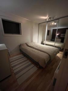 um quarto com uma cama e um espelho grande em Lykkebo em Tromsø