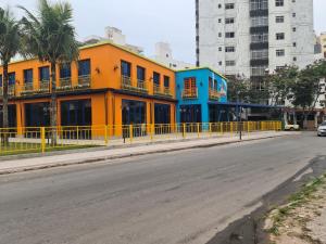un edificio colorido al lado de una calle en Praia do Morro Guarapari, en Guarapari