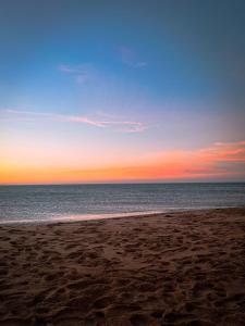 a sunset on a beach with the ocean at Beach house in Izâmmoûrâne +4 photos