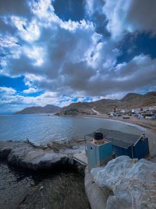 a body of water with a building on the shore at Beach house in Izâmmoûrâne