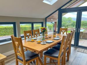 a dining room with a wooden table and chairs at Lake View luxury home with Lake Ullswater view & 2 ground floor bedrooms ideal for 2 families in Watermillock