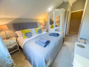 a bedroom with a large bed and a mirror at Lake View luxury home with Lake Ullswater view & 2 ground floor bedrooms ideal for 2 families in Watermillock