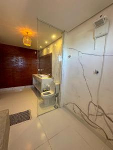 a bathroom with a toilet and a shower and a sink at Bem te quero Pipa- apt superior in Pipa