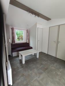 an empty room with a bench and a window at La Salicorne in Breuillet