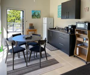 een keuken met een tafel, stoelen en een koelkast bij Matapouri & Tutukaka Spectacular Coastal Views- Aroha Luxury Guest Suite in Tutukaka +57 foto's