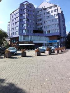 a large building with cars parked in a parking lot at DAION in Bistriţa