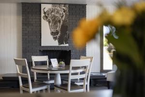 a table and chairs with a picture of a cow on the wall at Copperhead Lodge in Anaconda