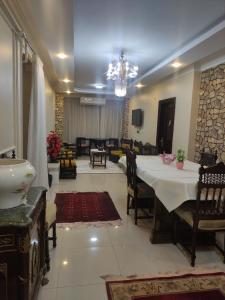 a dining room with a table and a living room at Diamond Pyramids View Apartment in Cairo