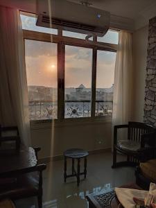 a room with a large window with a view at Diamond Pyramids View Apartment in Cairo