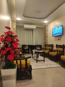 a lobby with a waiting room with tables and a tv at Diamond Pyramids View Apartment in Cairo